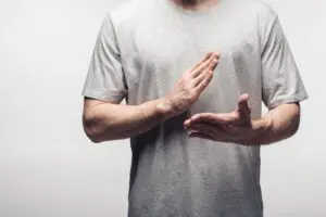 cropped view of man gesturing with hands while using body language isolated on grey, human emotion